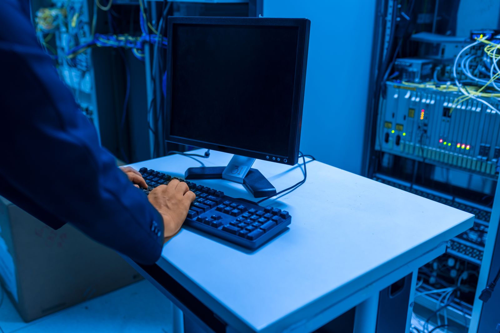 Technician working beside server and network equipment in a data centre.